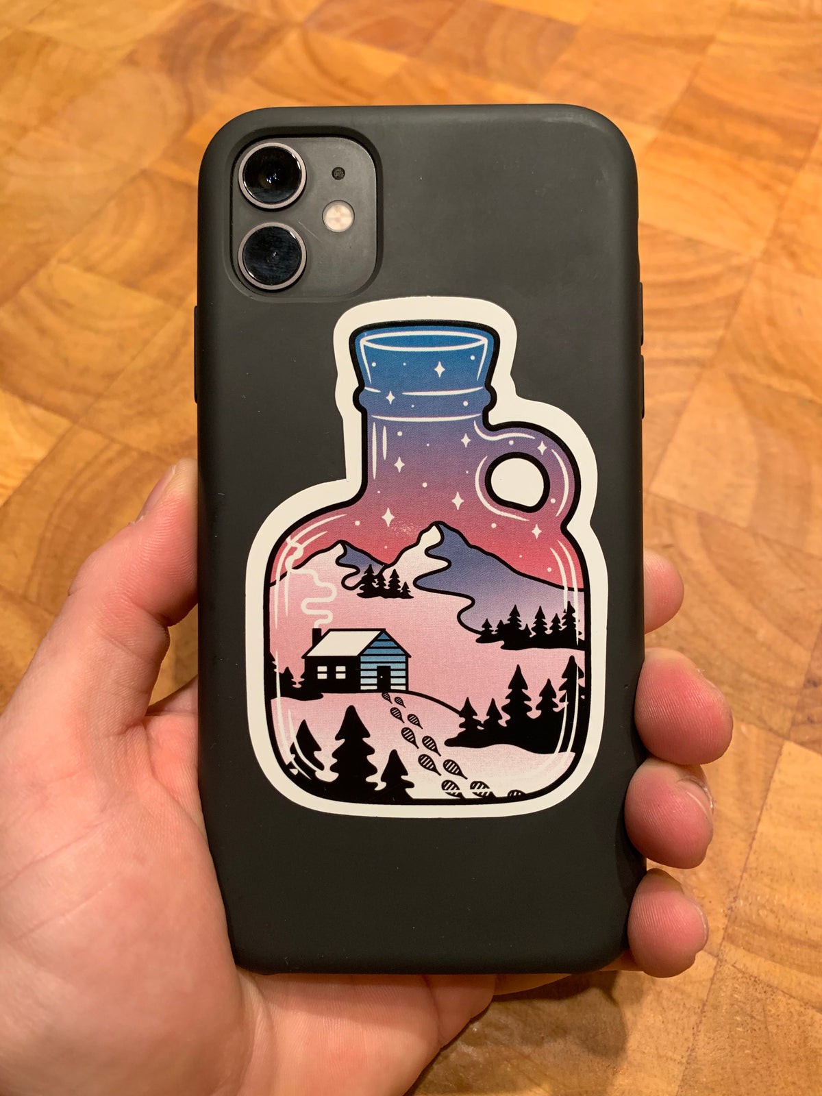 Cozy cabin sticker overlooking mountains on a phone
