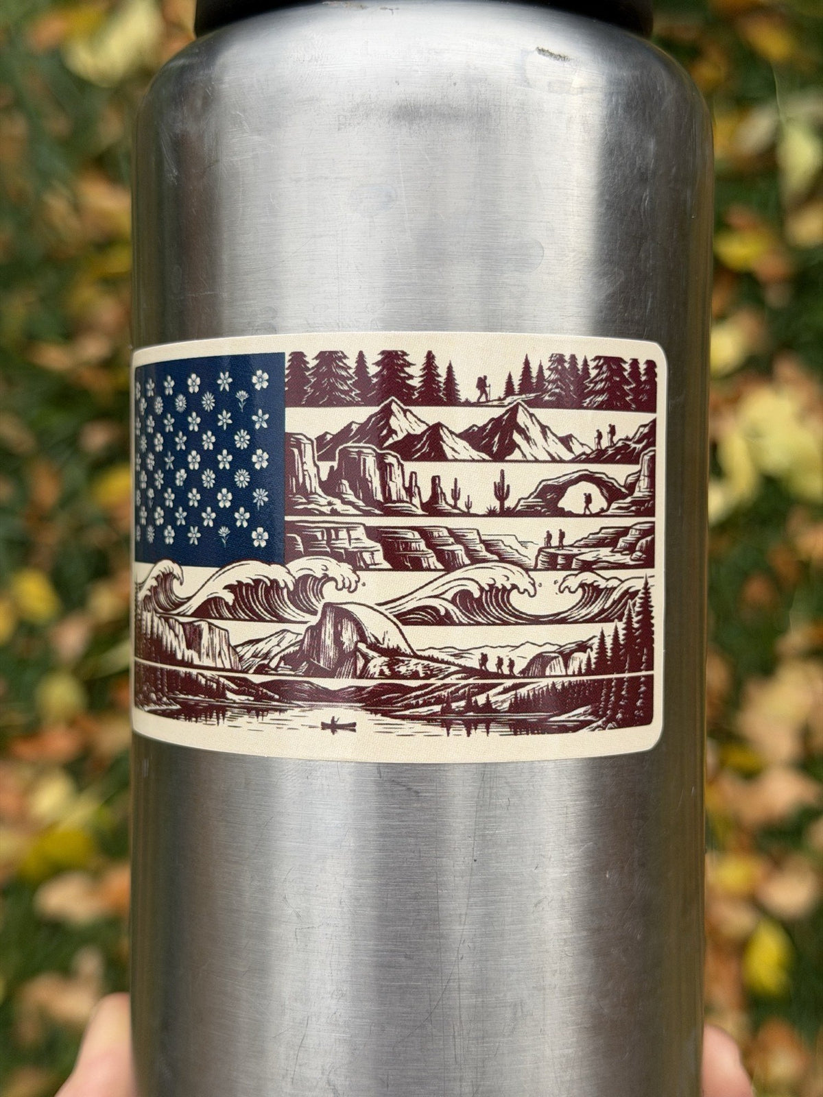 Close-up of engraved-style nature flag sticker on a water bottle