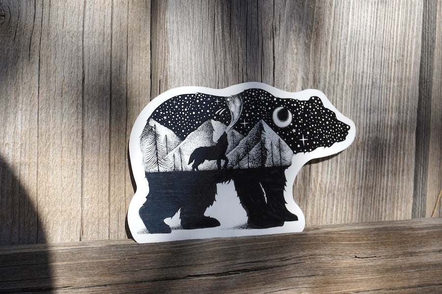 Black-and-white bear sticker displayed on weathered wood
