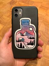 Cozy cabin sticker overlooking mountains on a phone