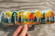 Autumn aspen forest water bottle wrap sticker held against rustic wood