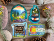 Four Colorado mountain, camping, wildflower and state-sign stickers on rustic wood
