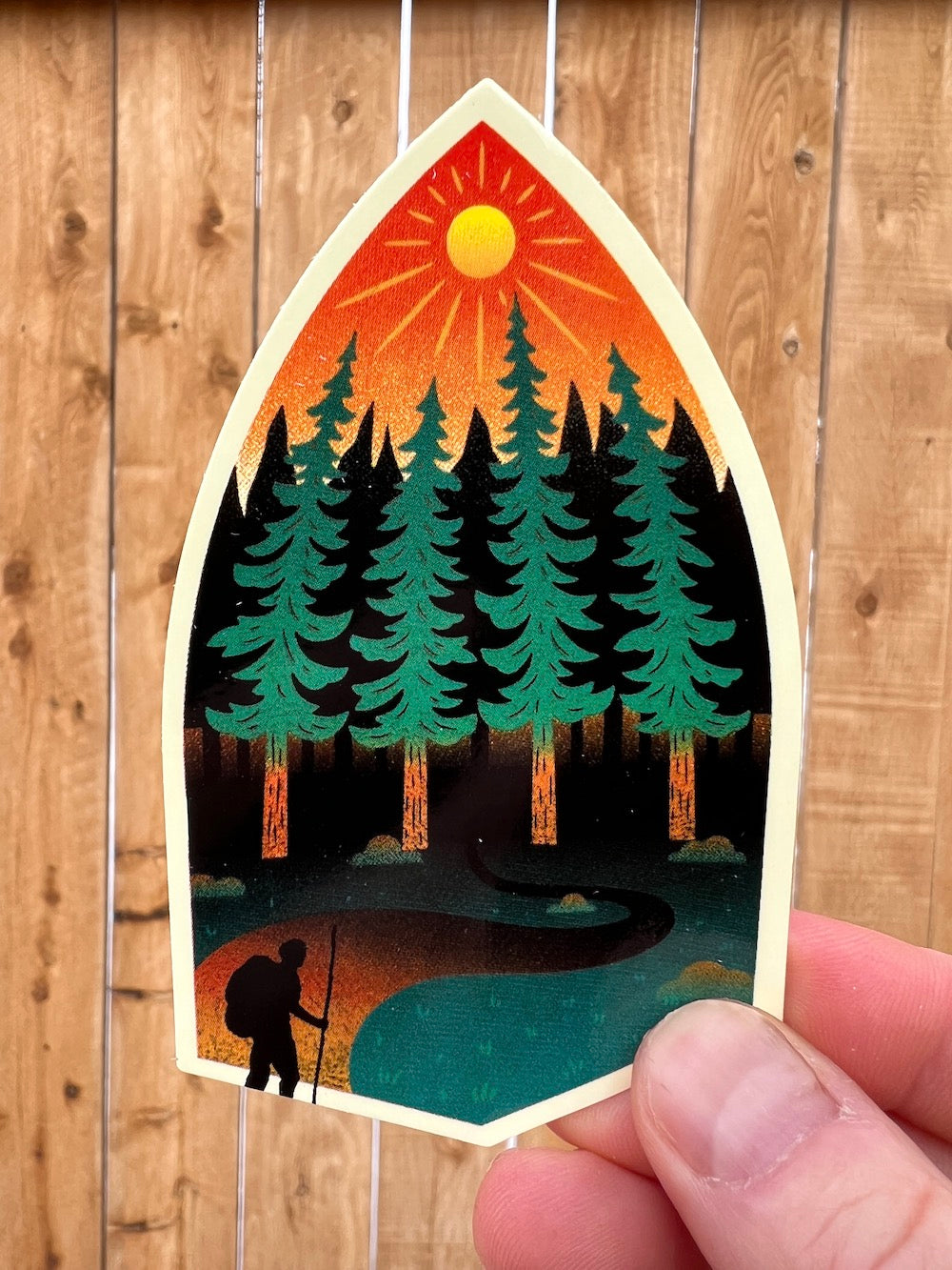 Backpacker hiking through a sunlit pine forest vinyl sticker