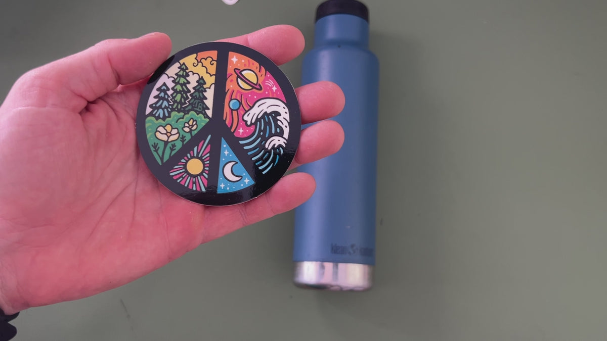 Applying the colorful nature peace sign sticker to a water bottle