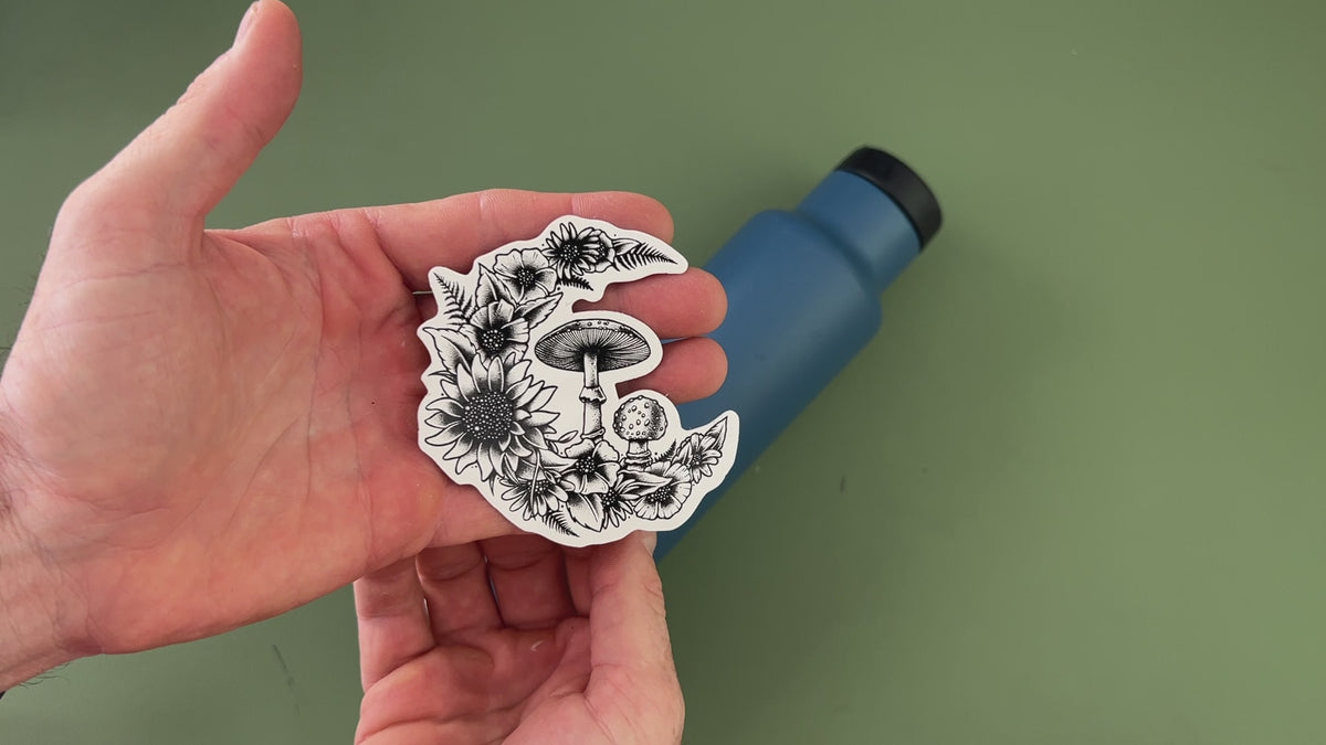 applying moon sticker to blue water bottle