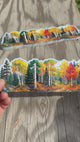 Applying the autumn aspen forest wrap sticker to a water bottle