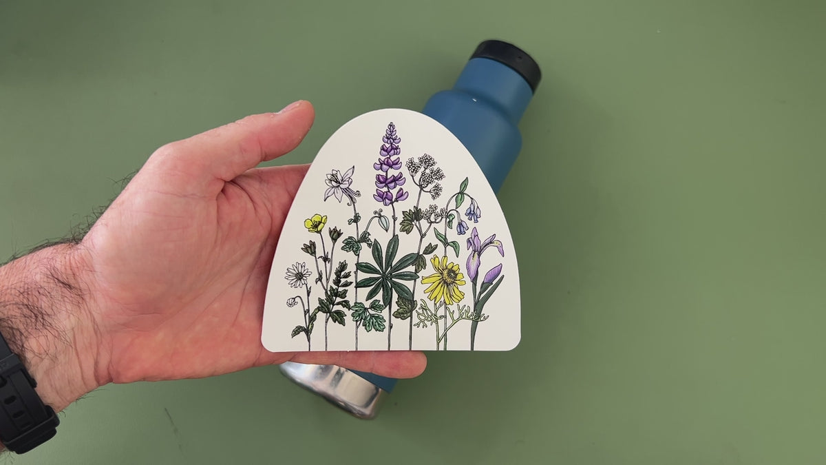 Applying the watercolor wildflower sticker to a water bottle