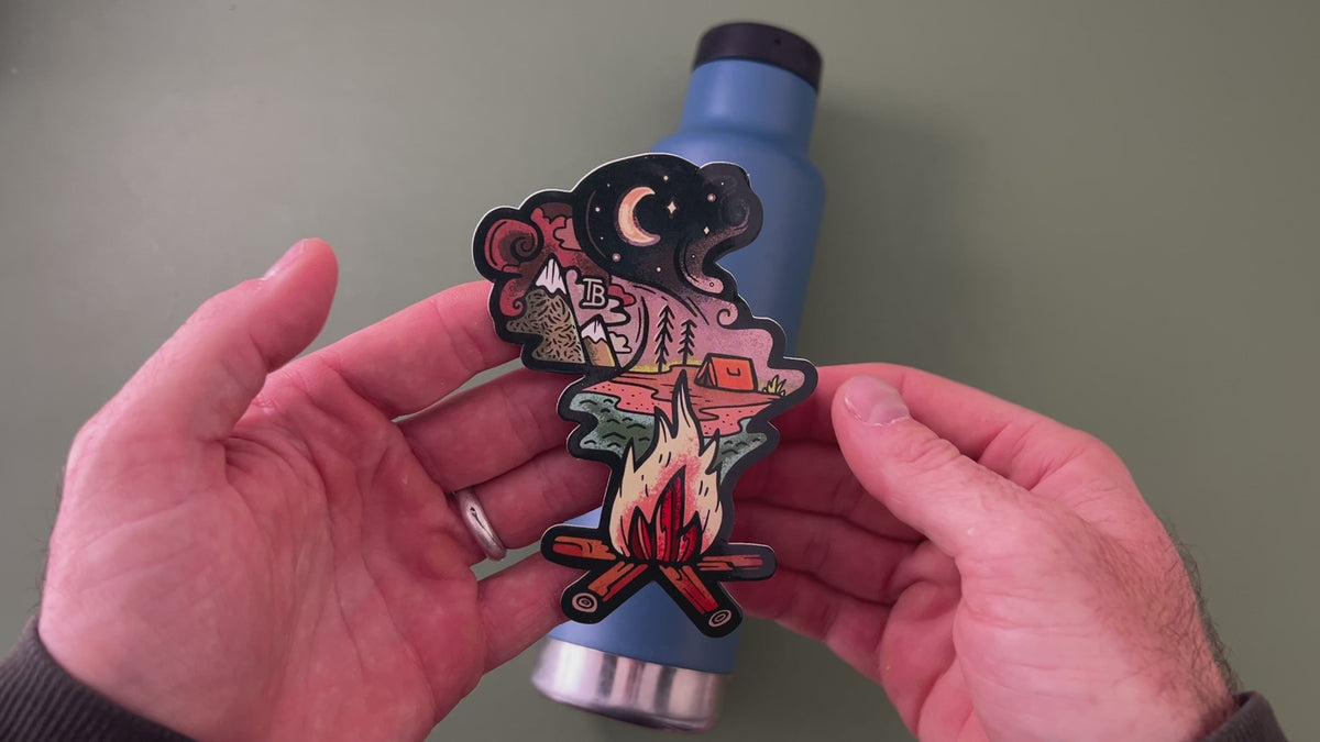 Applying the Campfire Dreaming sticker to a water bottle