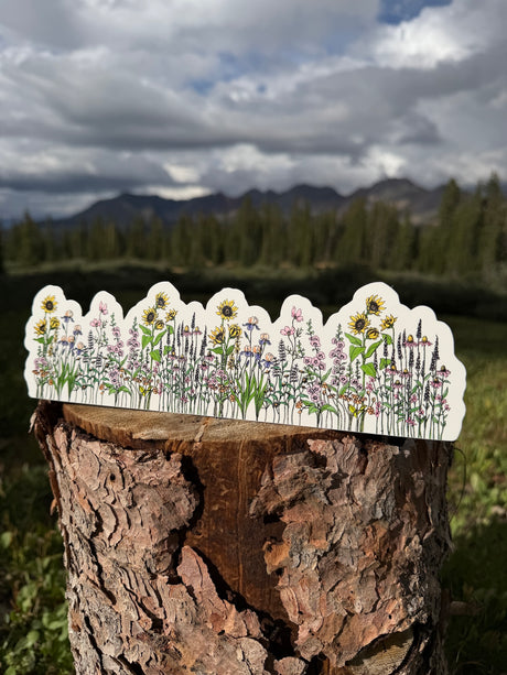 Wildflower garden water bottle wrap sticker displayed in the mountains